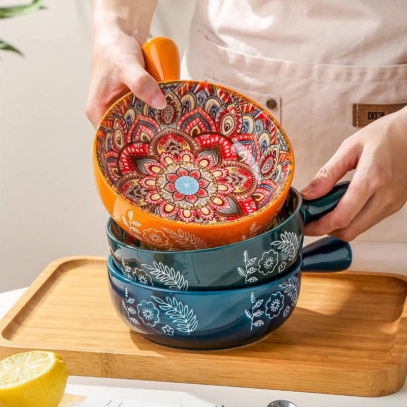 Elegant ceramic bowls with floral handles in blue, red, and green glazed finishes, perfect for serving salads and desserts