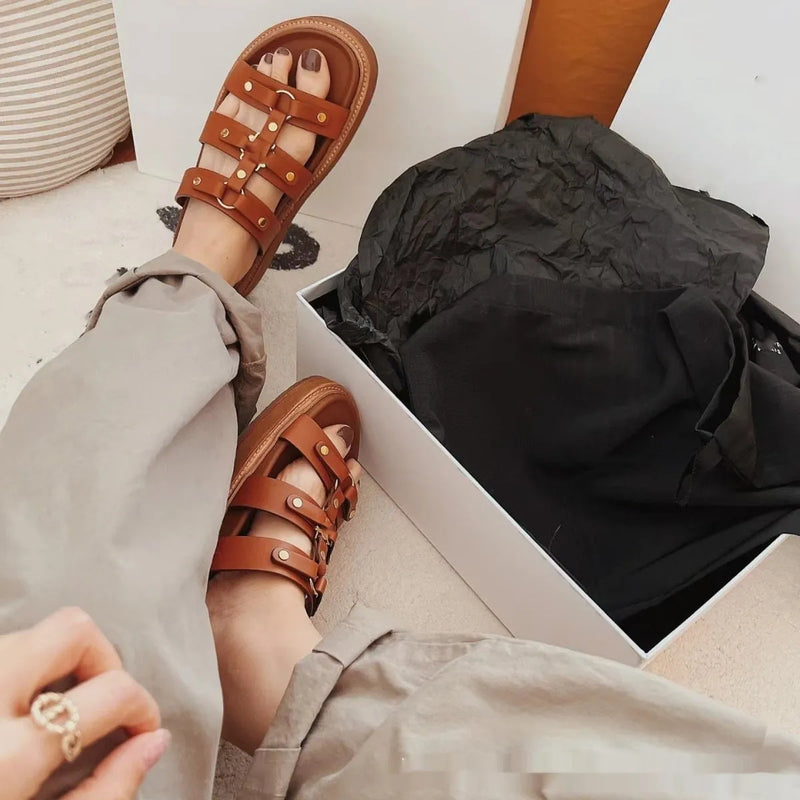 Women's Roman style sandal slippers in a retro versatile design featuring a patent leather and sheepskin upper construction with a solid colour pattern available in white, black and brown and sizes ranging from EU 35 to EU 42 for a comfortable casual fit.