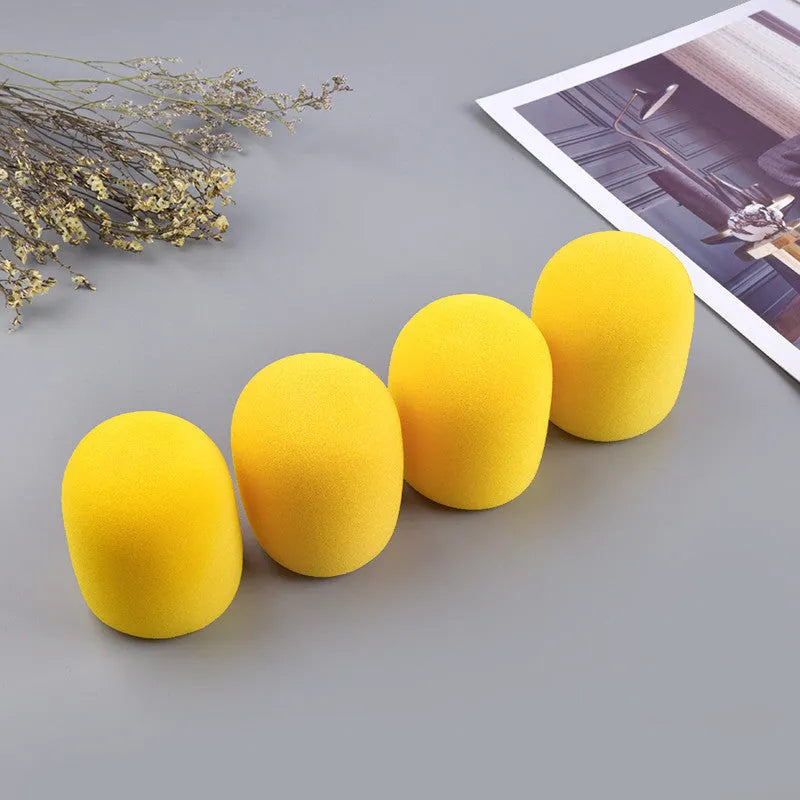 Four foam microphone wind shields in different colours for handheld stage microphones