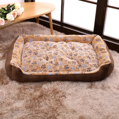 Beige plush pet bed for small dogs with a removable cover and non-slip base, shown in a home setting.