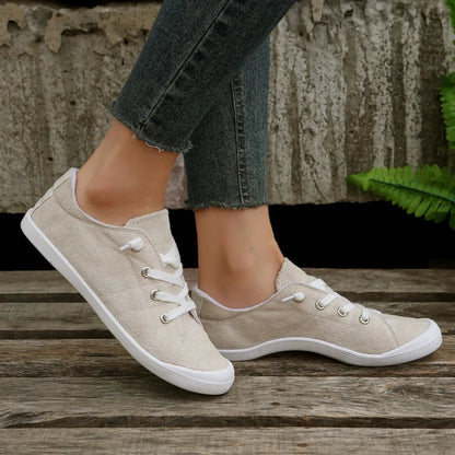 Women's creamy white low-top casual sneaker with fabric upper and rubber sole.