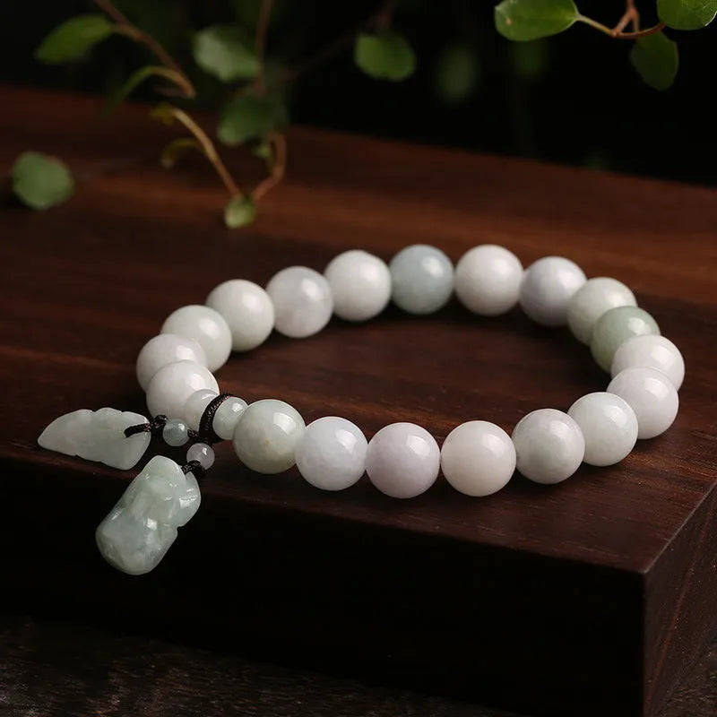 Natural green jade charm bracelet with carved apple and geometric stone pendants.