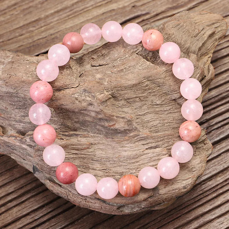 Natural stone bead necklace and bracelet set with a long fringe tassel pendant on a table.