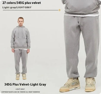 Man wearing solid colour cotton velvet sweatpants with an ankle banded design in a dark grey shade.