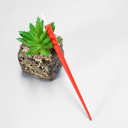 Diamond painting repair tool set with metal scraper pen, bottle of adhesive liquid, soft brush, and bamboo stick on a craft table
