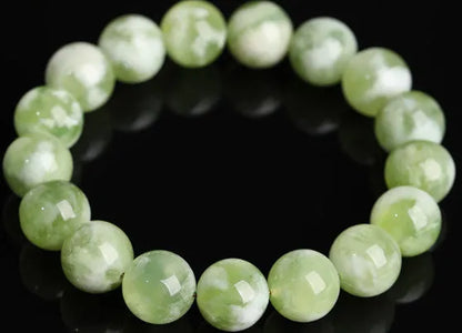 Green milk-in-water Xiuyan jade bracelet with polished geometric beads.