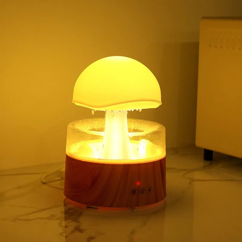 White cloud-shaped humidifier emitting mist with multicoloured LED light and water droplets