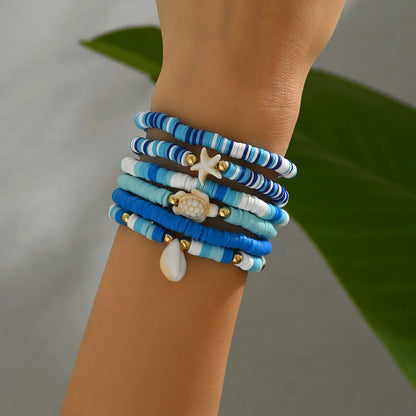 Six handmade Bohemian Blue polymer clay bracelets with geometric shell designs arranged together