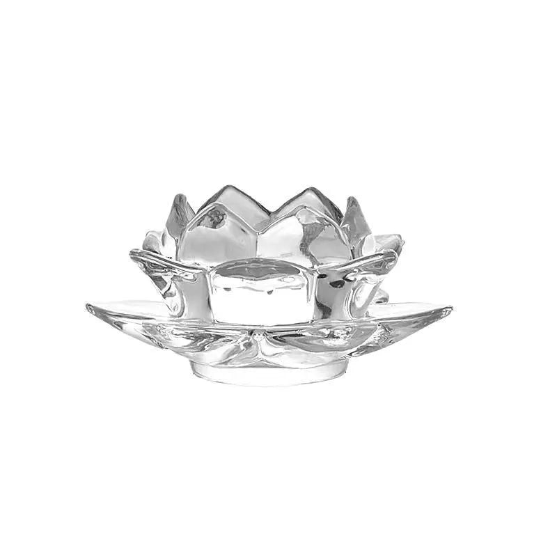 Glass lotus-shaped aromatherapy candle cup on a table.