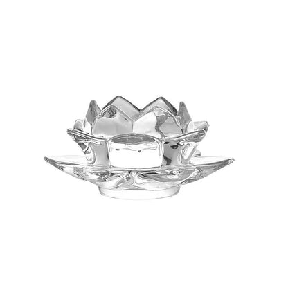 Glass lotus-shaped aromatherapy candle cup on a table.