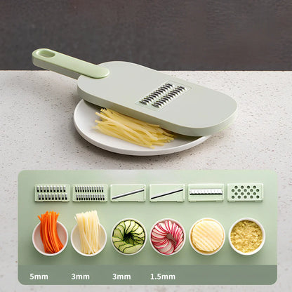 Shredded vegetable slicer with stainless steel blades on green cutting board
