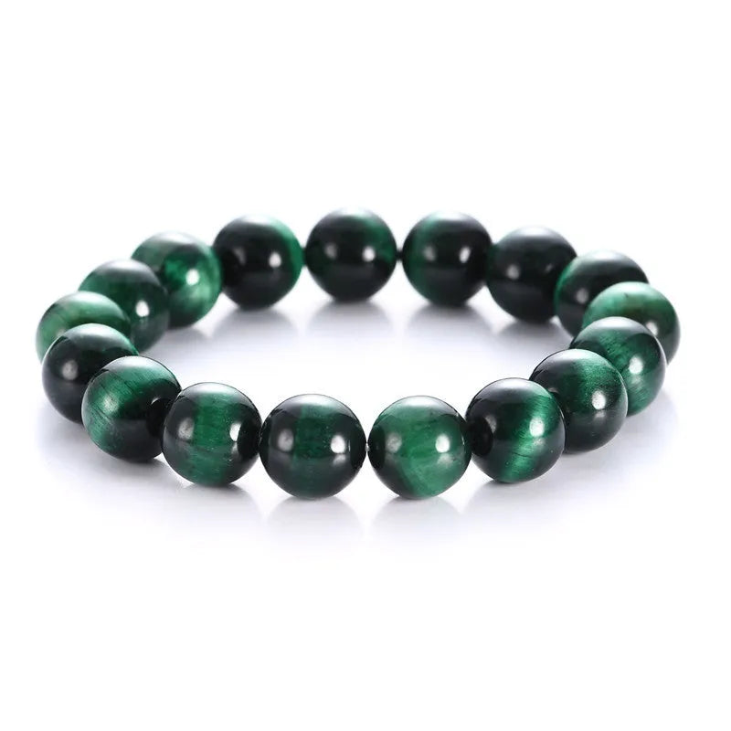 Green tiger's eye stone bracelet with geometric beads on a wrist.