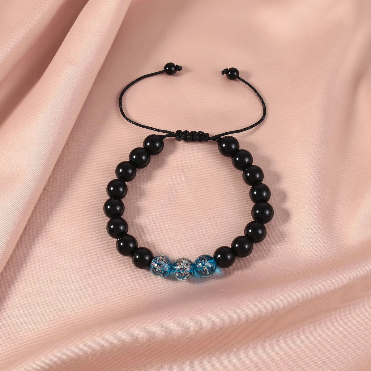 Adjustable luminous beaded bracelet with geometric glass beads on a stretchy elastic band in sapphire blue
