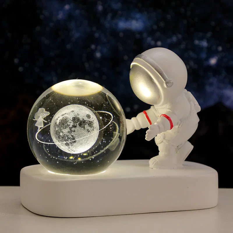 Glowing astronaut crystal ball night light with 6cm diameter and USB cable on wooden surface