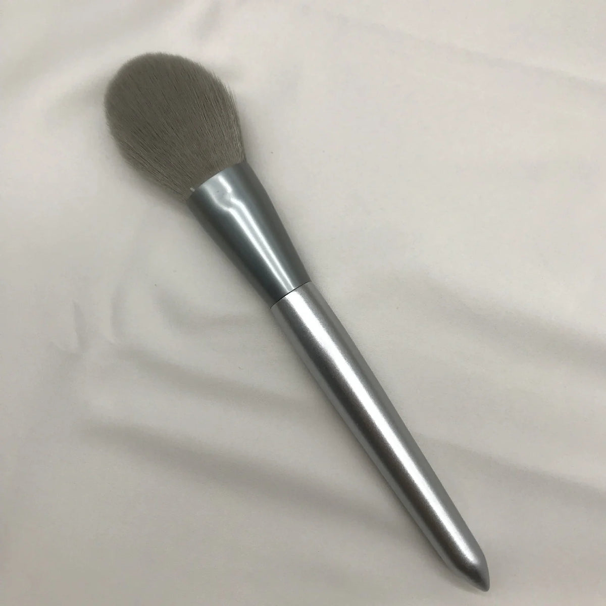 10 makeup brushes with moonlight silver finish and wooden handles beside PU brush bag