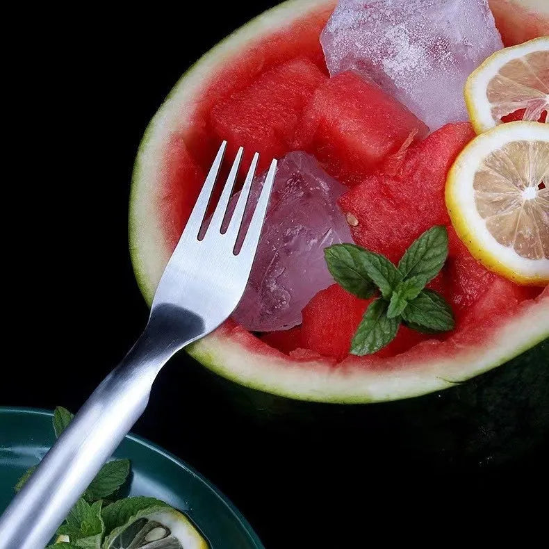 Stainless steel watermelon slicer and serving fork on a kitchen counter.