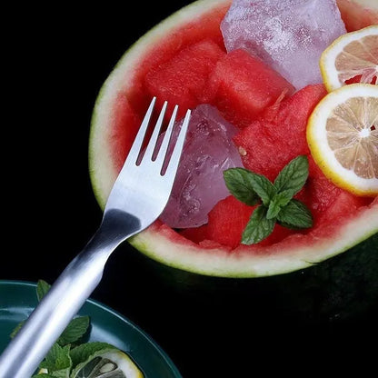 Stainless steel watermelon slicer and serving fork on a kitchen counter.