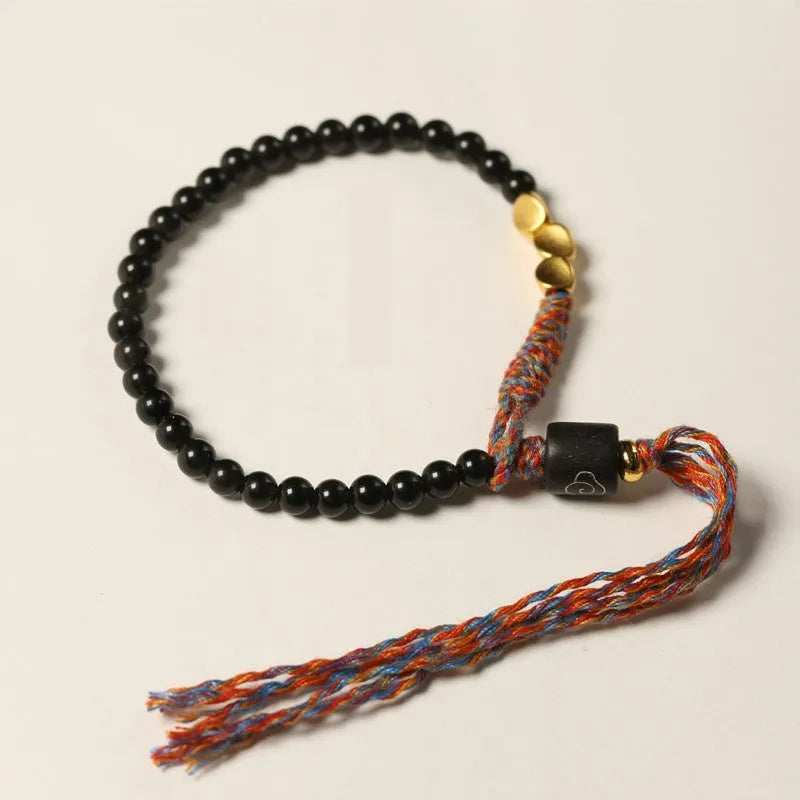 Close-up of a hand-woven obsidian bracelet with a 4mm wide strap on a wrist.
