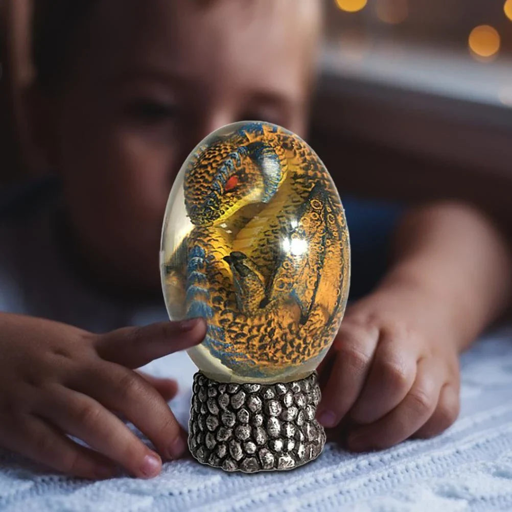 A lifelike resin dragon egg ornament with a crystal-clear, transparent design, sitting on a glowing lava-style base.