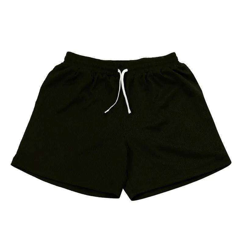 Men's black mesh athletic shorts with built-in liner on a grey background.