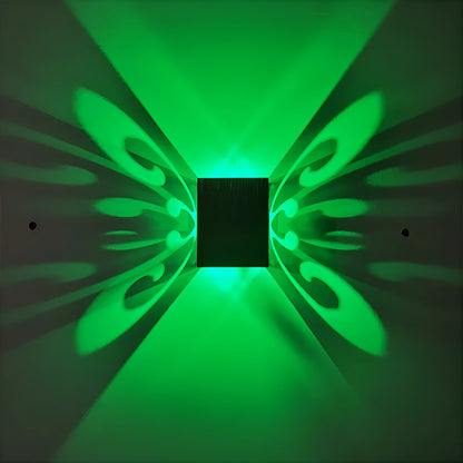 Modern aluminium butterfly-shaped LED wall lamp with colour-changing lights on a plain wall
