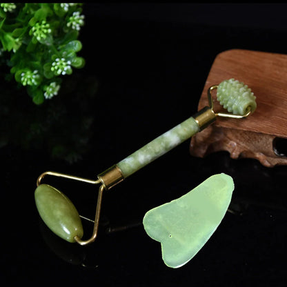 Natural green jade beauty massager with roller and scraper tools on white background