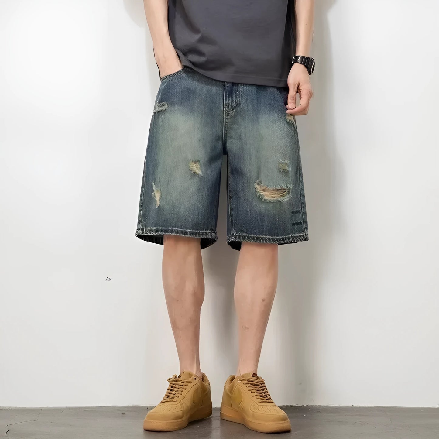 Men's blue loose fit denim shorts with distressed holes and straight leg