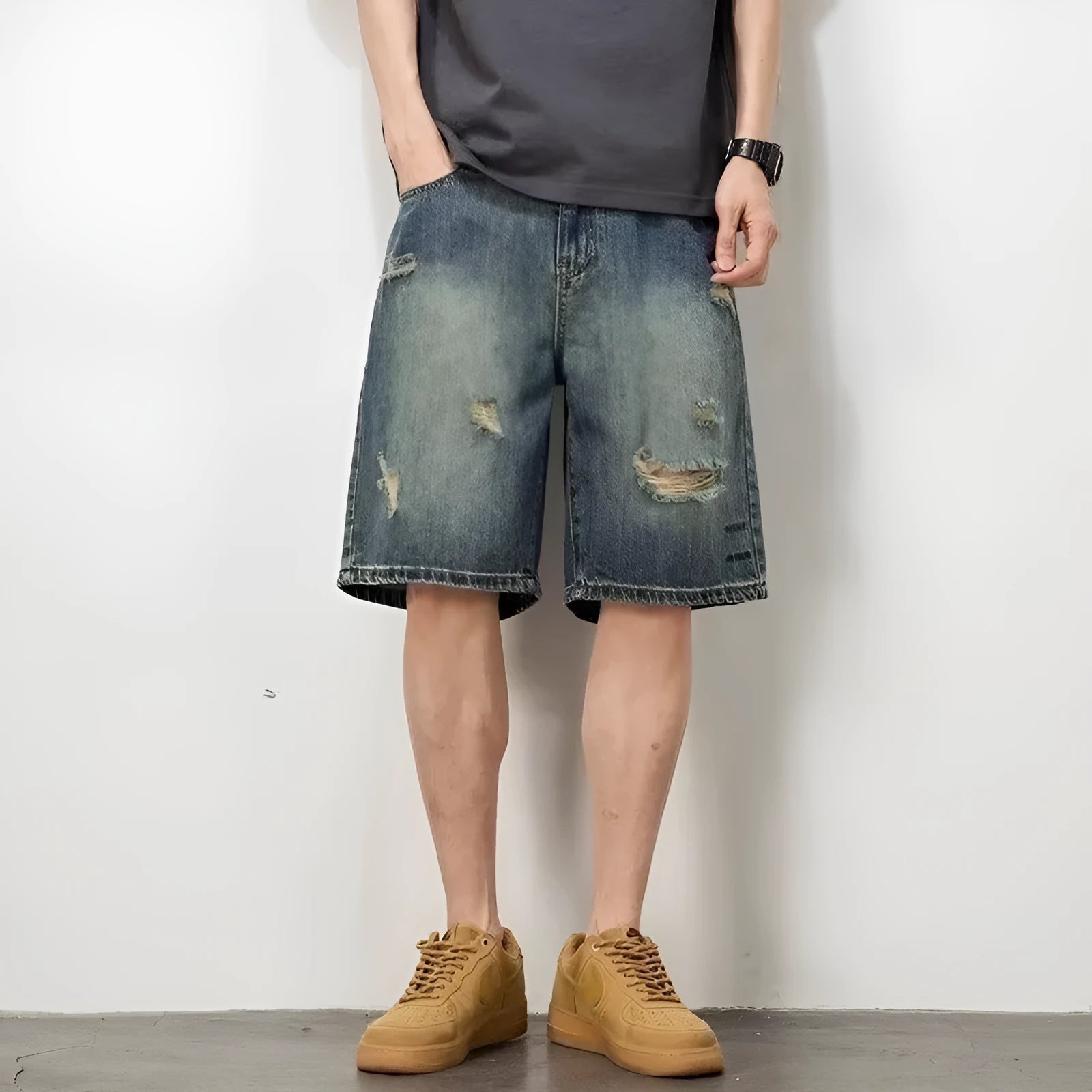 Men's blue loose fit denim shorts with distressed holes and straight leg