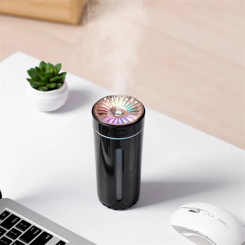 Black portable humidifier with LED lights beside car cup holder showing mist output
