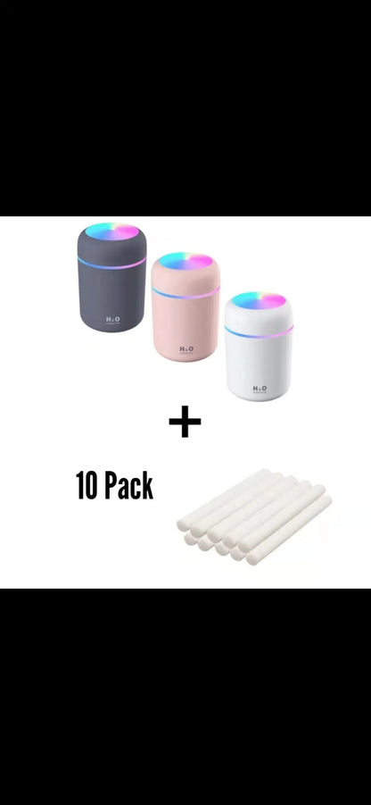 Pink USB desktop humidifier with LED lights and water tank on wooden desk