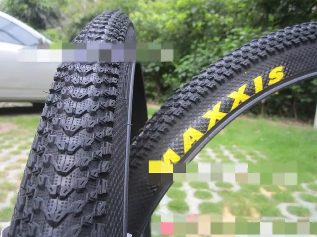 Mountain bike tyre with black tread and sidewall, showing size options like 26x1.95 and 29x2.1 inches for off-road cycling.