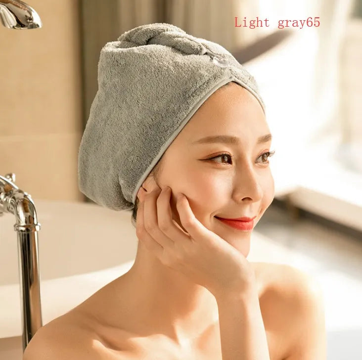 A woman wearing a sky blue microfiber hair dryer cap, with wet hair tucked inside, showing the towel's wrap-around design.