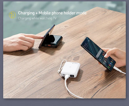 Small square black wireless charging power bank with LED display showing battery percentage.