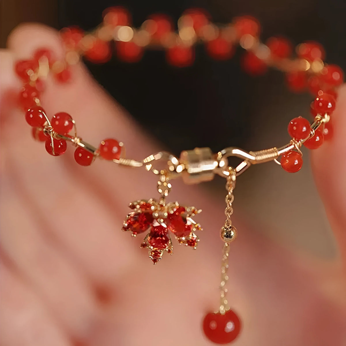 Red ginkgo leaf charm magnetic bracelet for girls on a wrist, showing maple leaf design details.