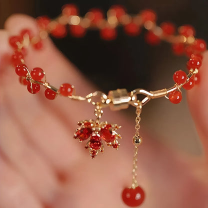 Red ginkgo leaf charm magnetic bracelet for girls on a wrist, showing maple leaf design details.