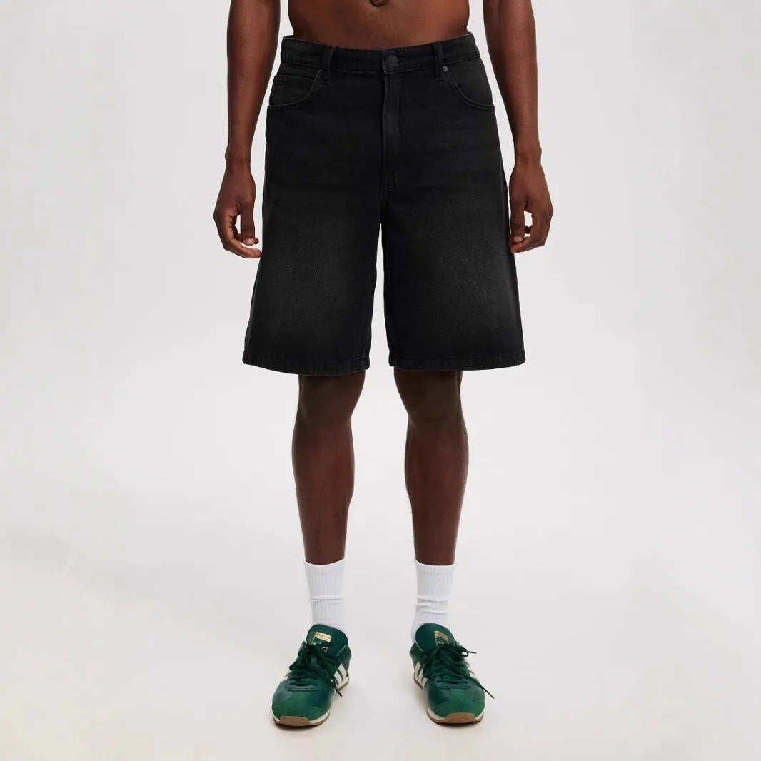 Men's light blue loose straight-leg cotton jeans laid flat, showing the front design and fifth-pants length.