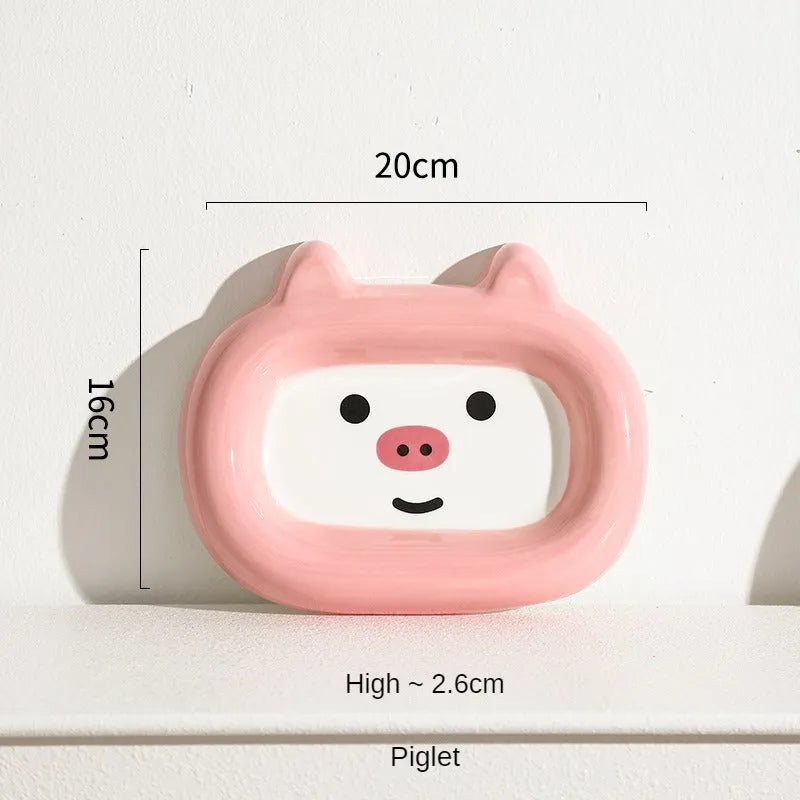 Four ceramic animal-themed pet bowls with frog, panda, pig, and fortune cat designs and silicone non-slip bases