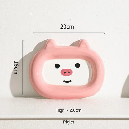 Four ceramic animal-themed pet bowls with frog, panda, pig, and fortune cat designs and silicone non-slip bases