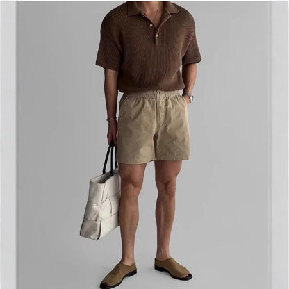 Cotton loose-fit sports shorts in black, shown on a hanger.