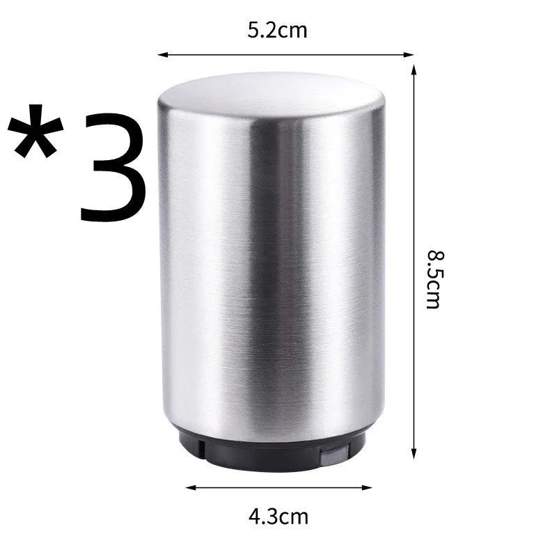 Stainless steel automatic bottle opener measuring 8.4 cm by 5.3 cm on a kitchen counter