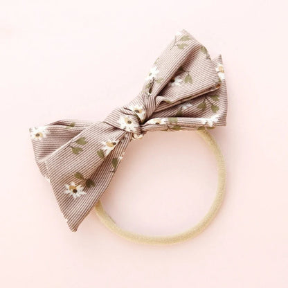 Children's cloth hair band with knotted bow design in one of six colour options