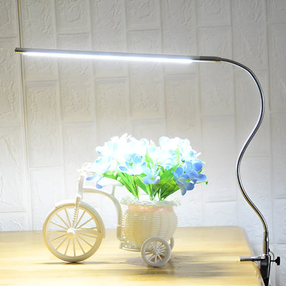 Silver aluminium alloy USB-powered LED nail table lamp with a long arm clip attached to a table edge.
