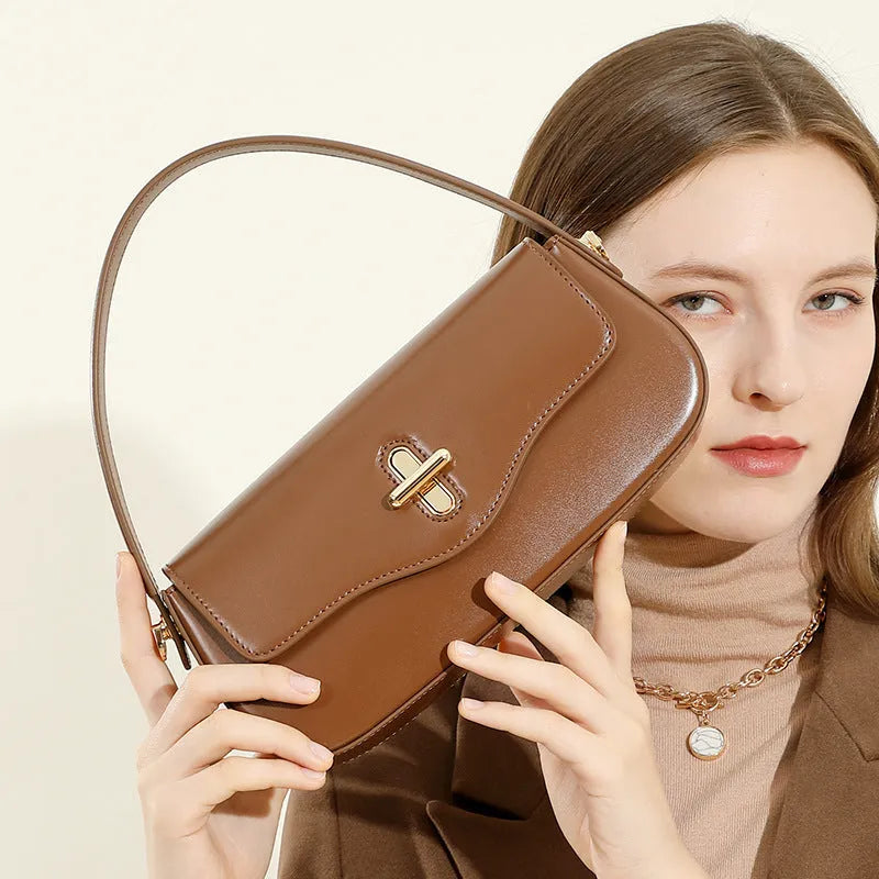 Genuine leather baguette handbag in horizontal square shape with clamshell opening and internal zip compartments