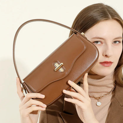 Genuine leather baguette handbag in horizontal square shape with clamshell opening and internal zip compartments