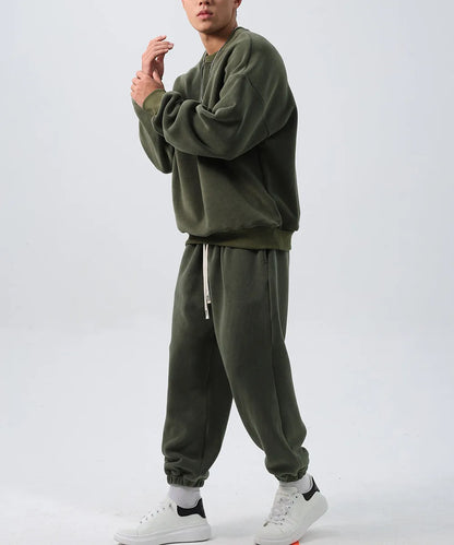 Man wearing a loose-fit army green polar fleece jacket and matching padded trousers from a winter tracksuit set.