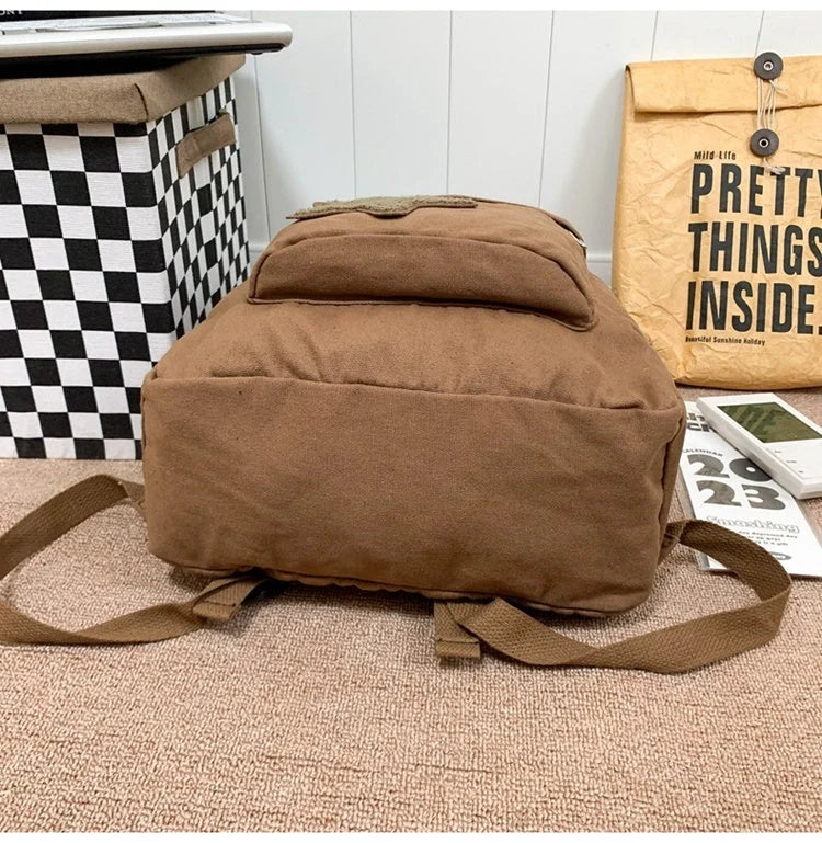 Brown canvas backpack with geometric patterns, ideal for female college students