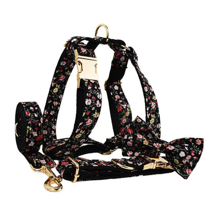 Four-piece dog accessory set showing a cloth collar, leash, vest, and removable bow with printed lettering.