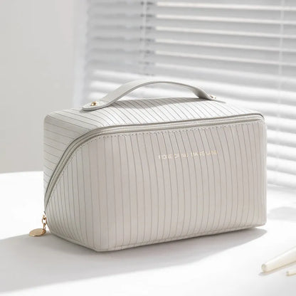 Beige cubic makeup bag with vertical pattern measuring 22.5 by 12.5 by 12.5 centimetres