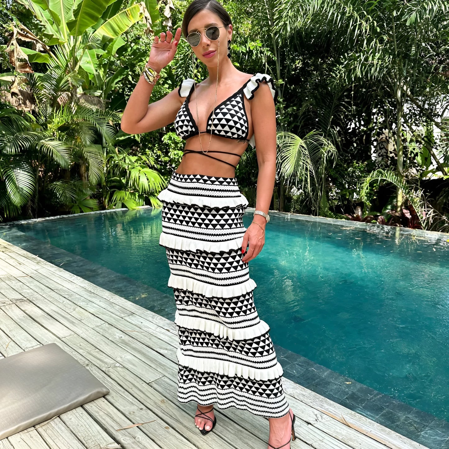 Black and white striped women's bikini set with ruffled top and long skirt on a hanger.