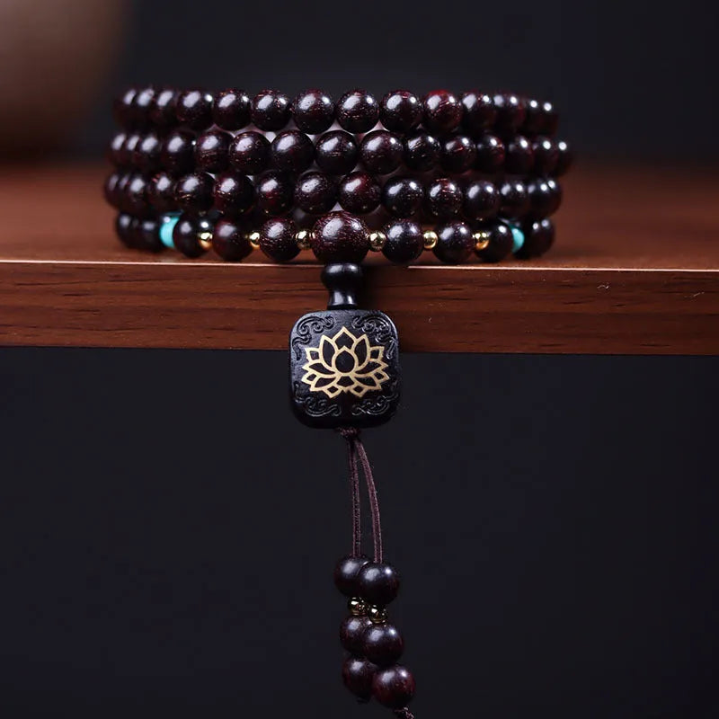 Zambia rosewood bead bracelet with 108 beads and flat lotus pendant on wooden surface